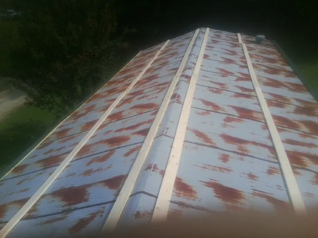 Rusted metal roof panels with new wood purlins before replacement — Storm Damage Roof Repair in Brewton by Roofing Brothers