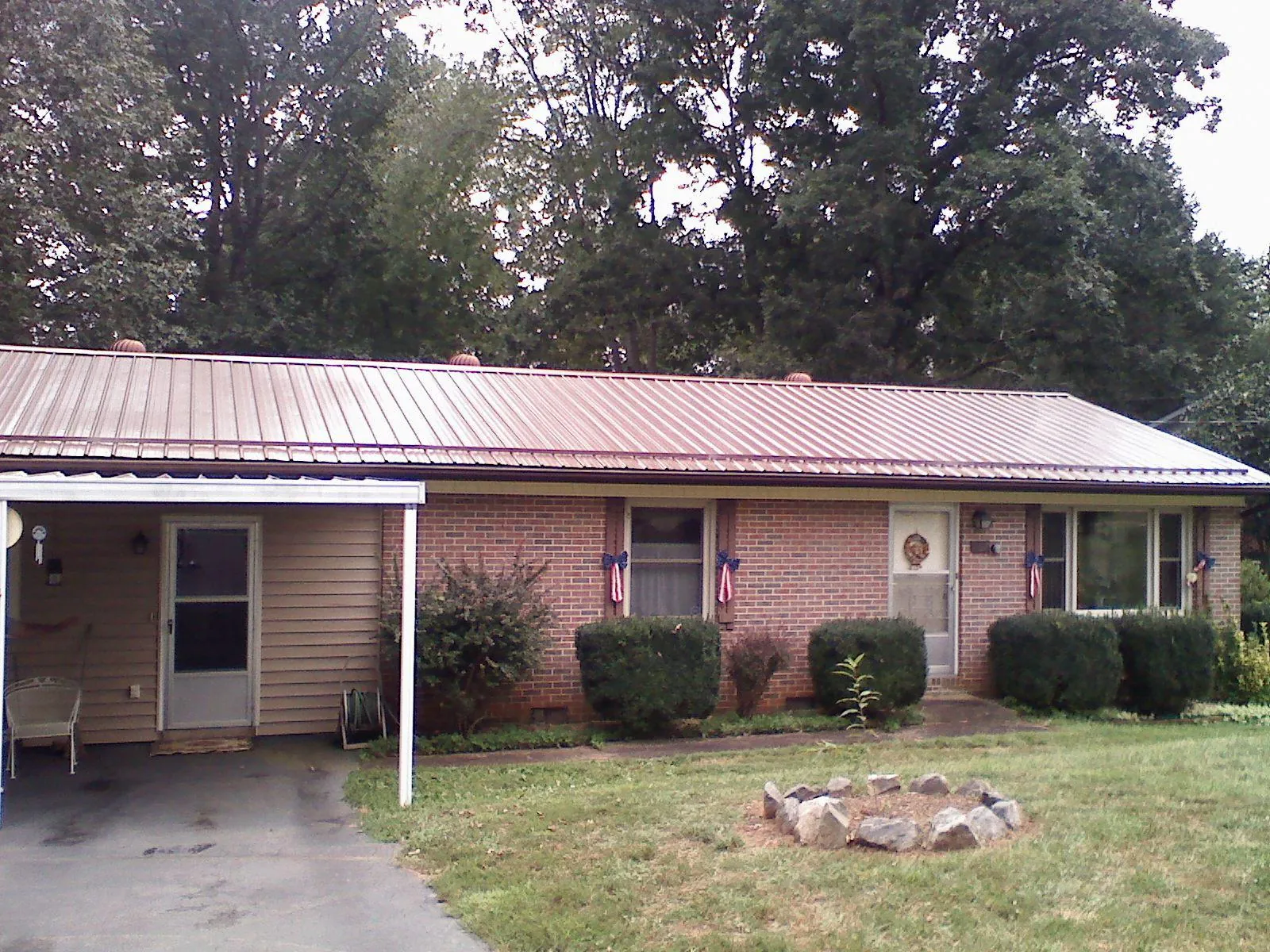 Bronze metal roof and carport on a brick ranch home — Roof Repair work by our crew in Brewton